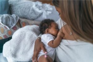 Mãe amamentando seu bebê em um ambiente aconchegante, transmitindo carinho e cuidado durante o momento de alimentação.